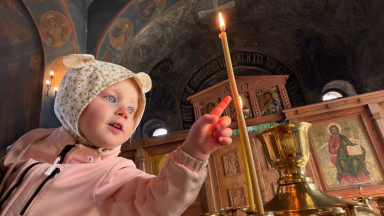 Ребенок тянет пальчик к свечке