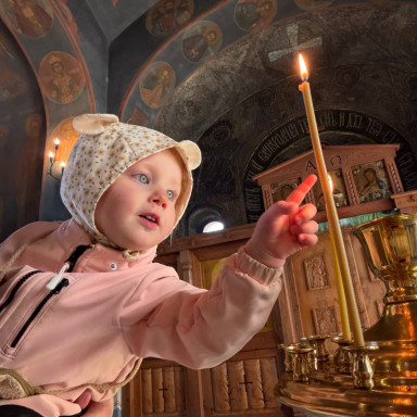 Ребенок тянет пальчик к свечке