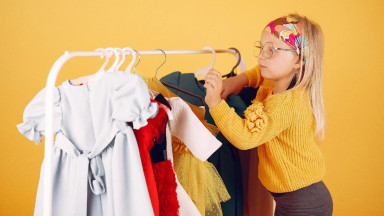 Девочка с одеждой на вешалке