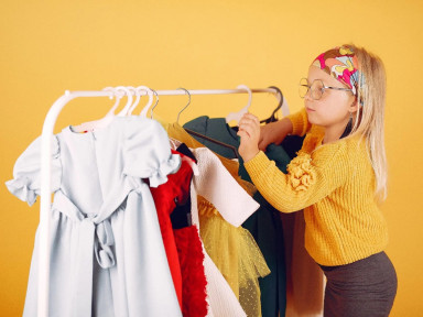 Девочка с одеждой на вешалке