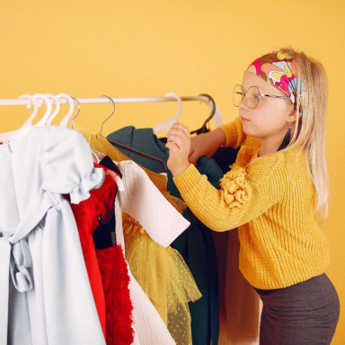 Девочка с одеждой на вешалке