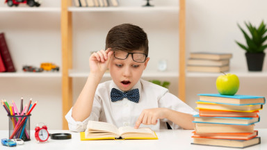 Ребенок с удивлением читает книгу